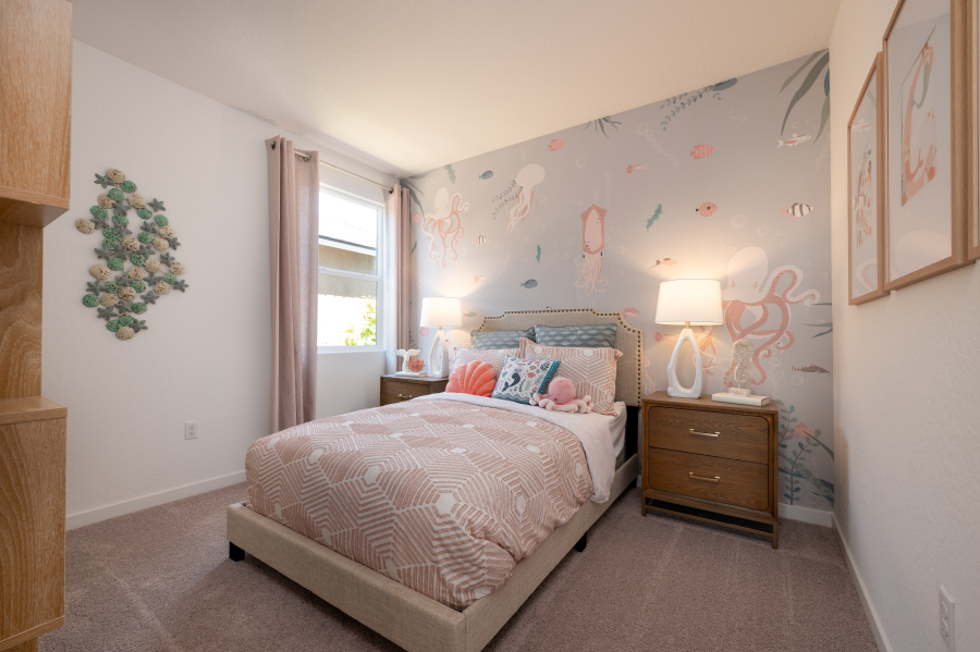 A bedroom with a bed and lamps.