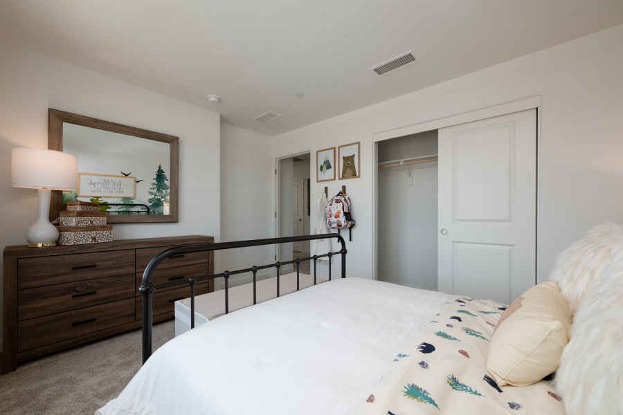 A bedroom with a bed and a mirror.