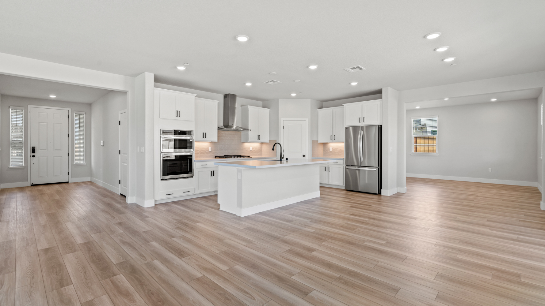 A kitchen with white cabinets.
