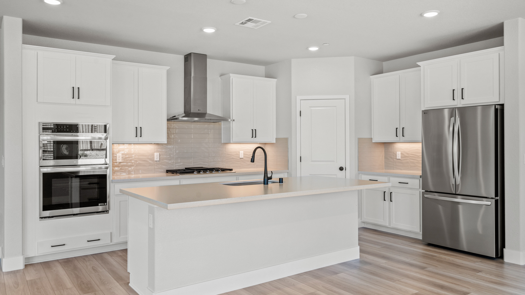 A kitchen with white cabinets.