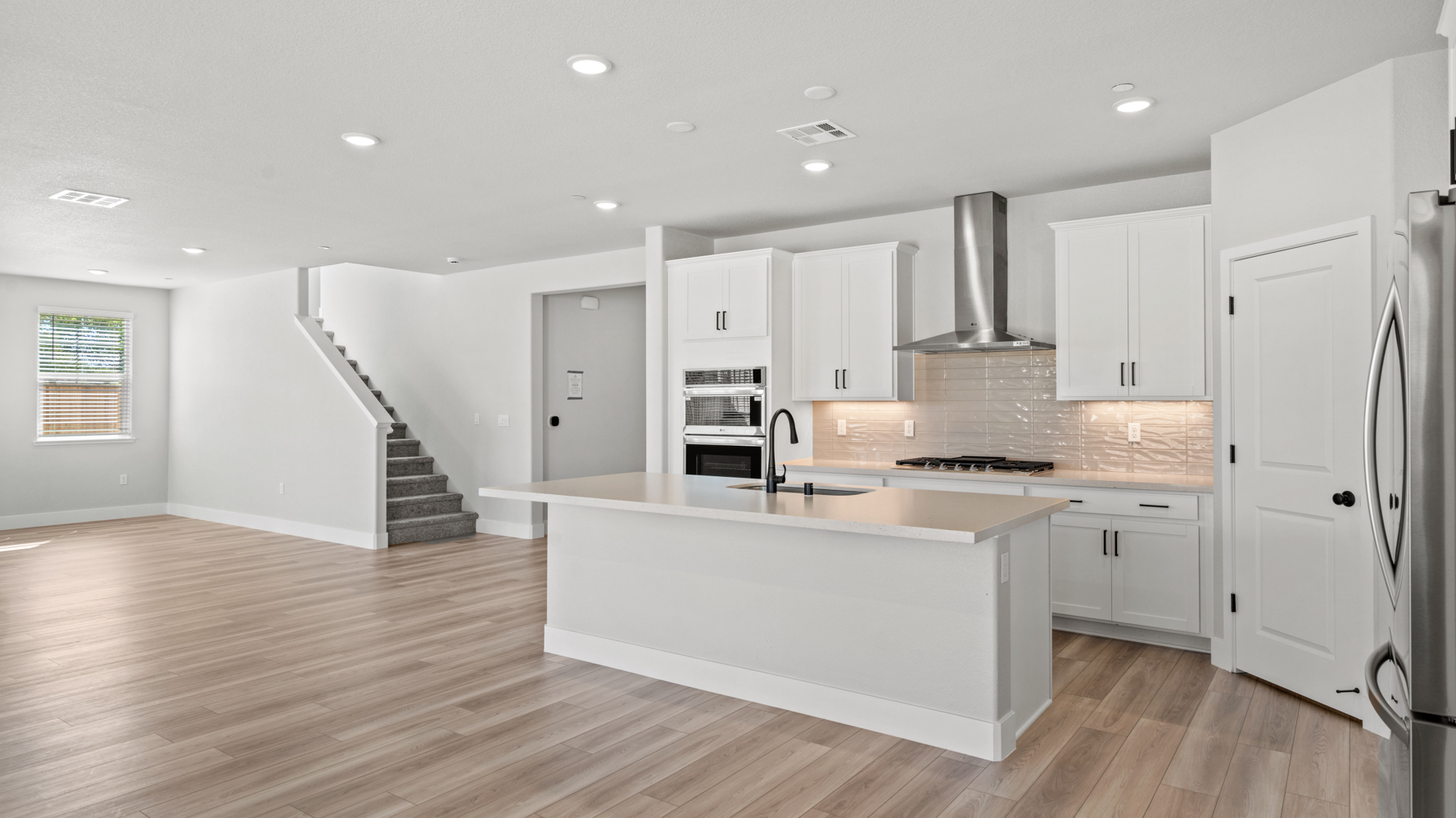A kitchen with white cabinets.