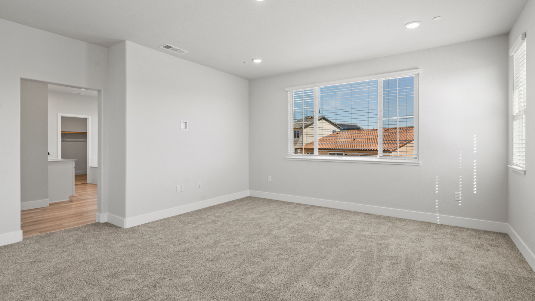 A room with a window and a rug.