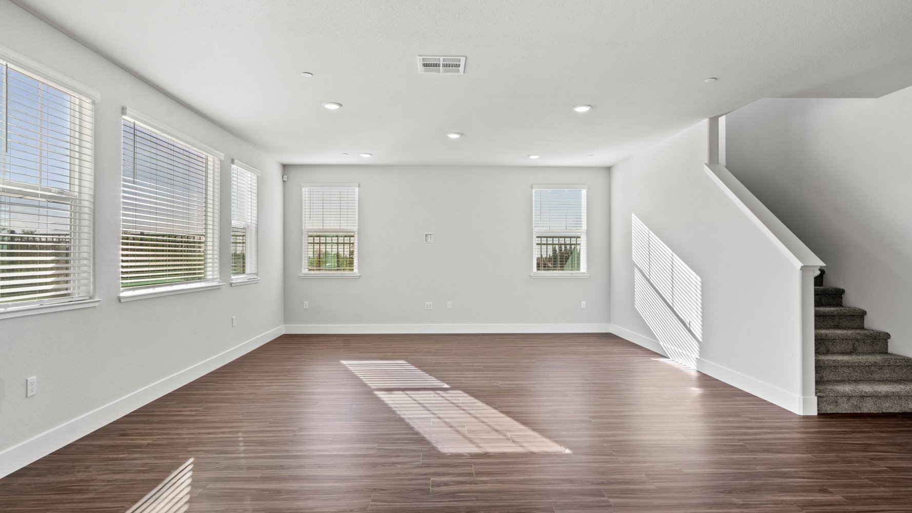 A room with a wood floor and windows.