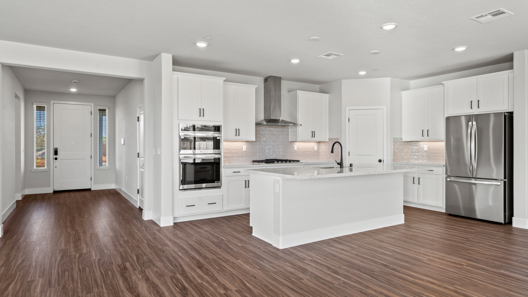 A kitchen with white cabinets.