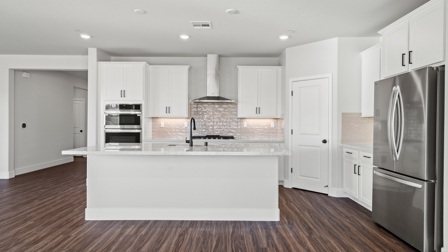 A kitchen with white cabinets.