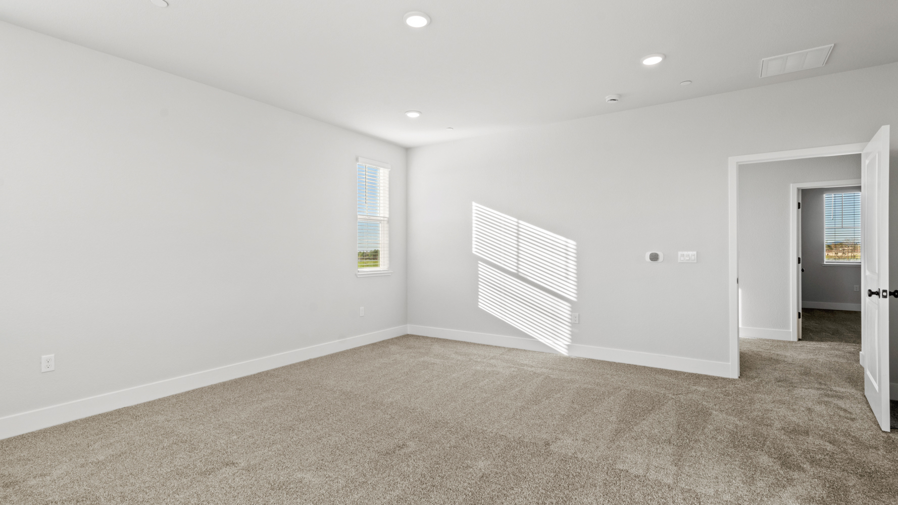 A room with a carpet and a door.