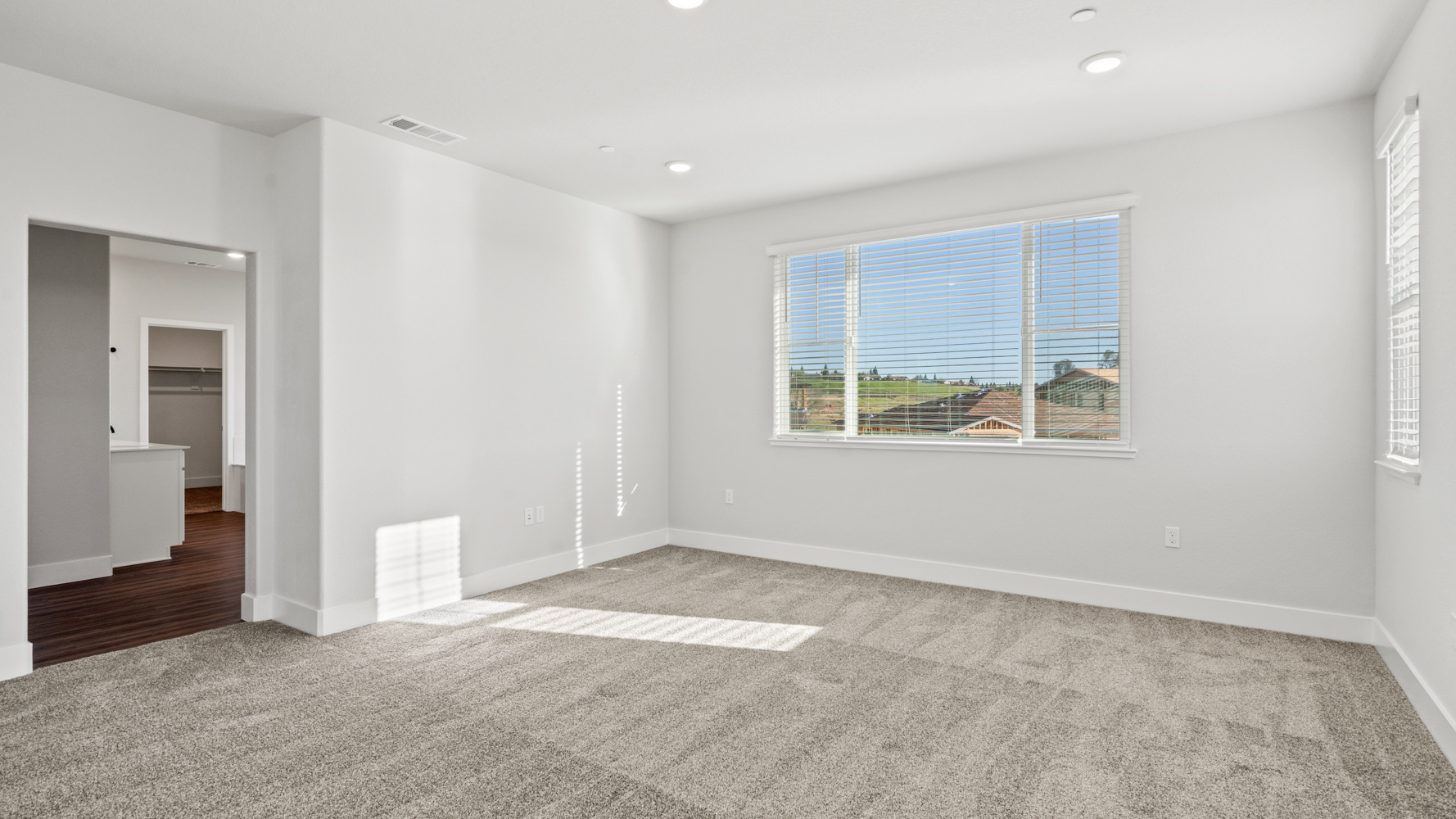 A room with a window and a rug.