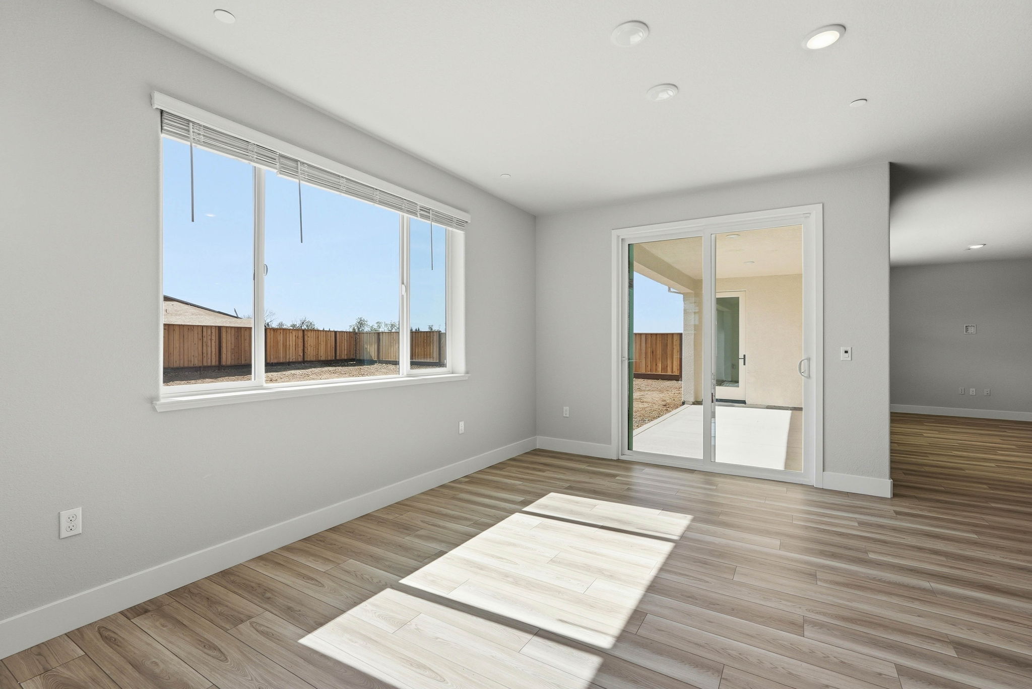 A room with a wood floor and a window with a wood floor.
