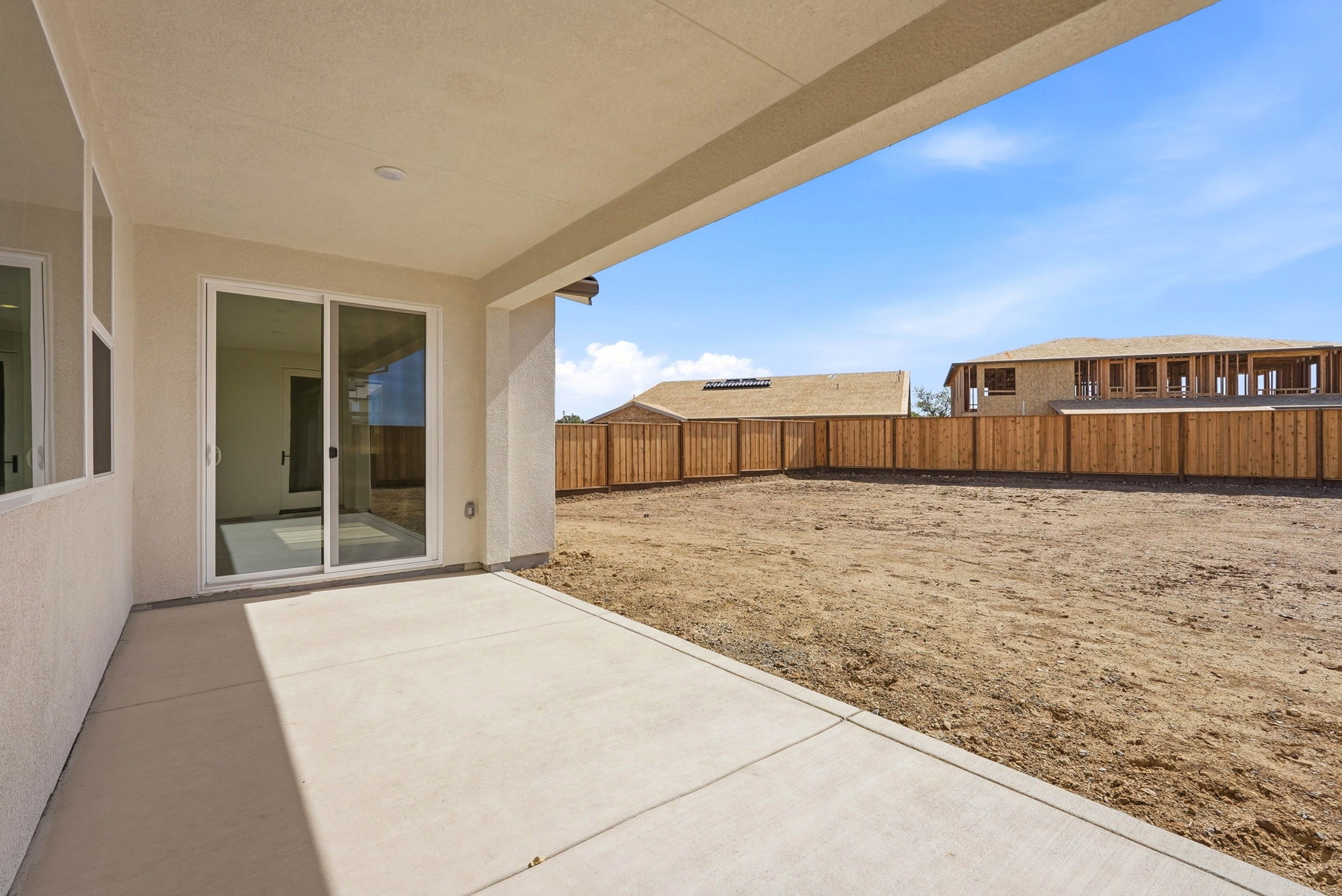 A house with a fence and a dirt yard.