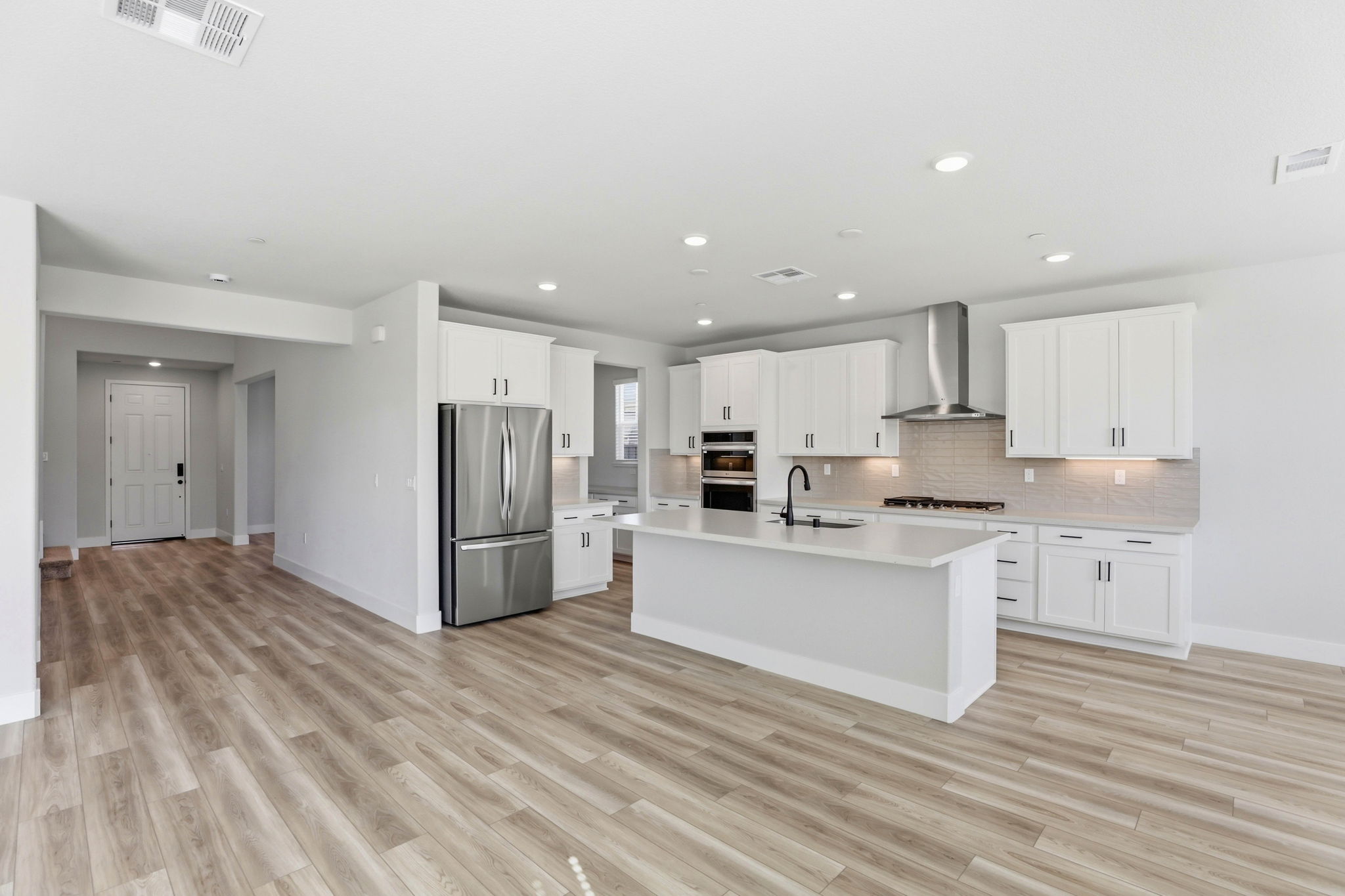 A kitchen with white cabinets.