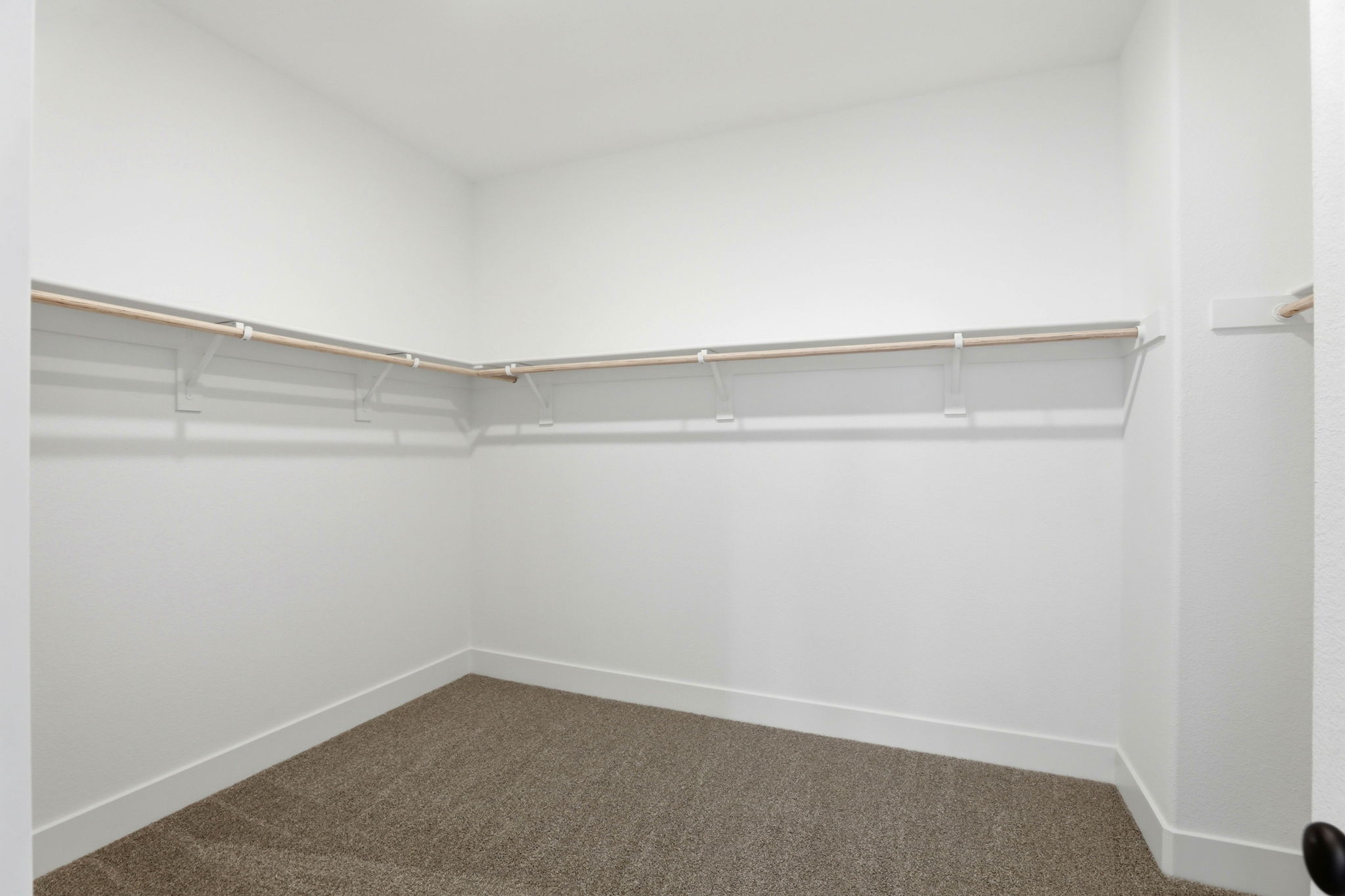 A white wall with a metal bar.