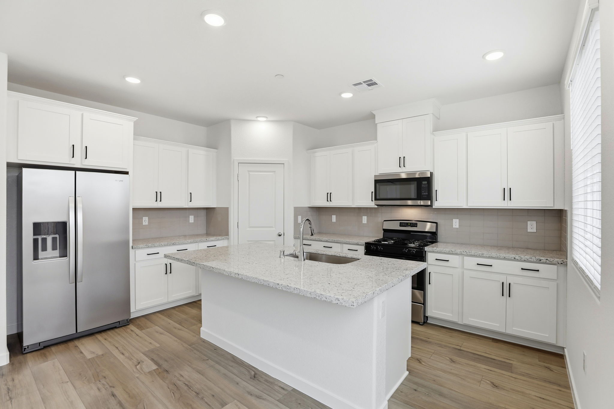 A kitchen with white cabinets.
