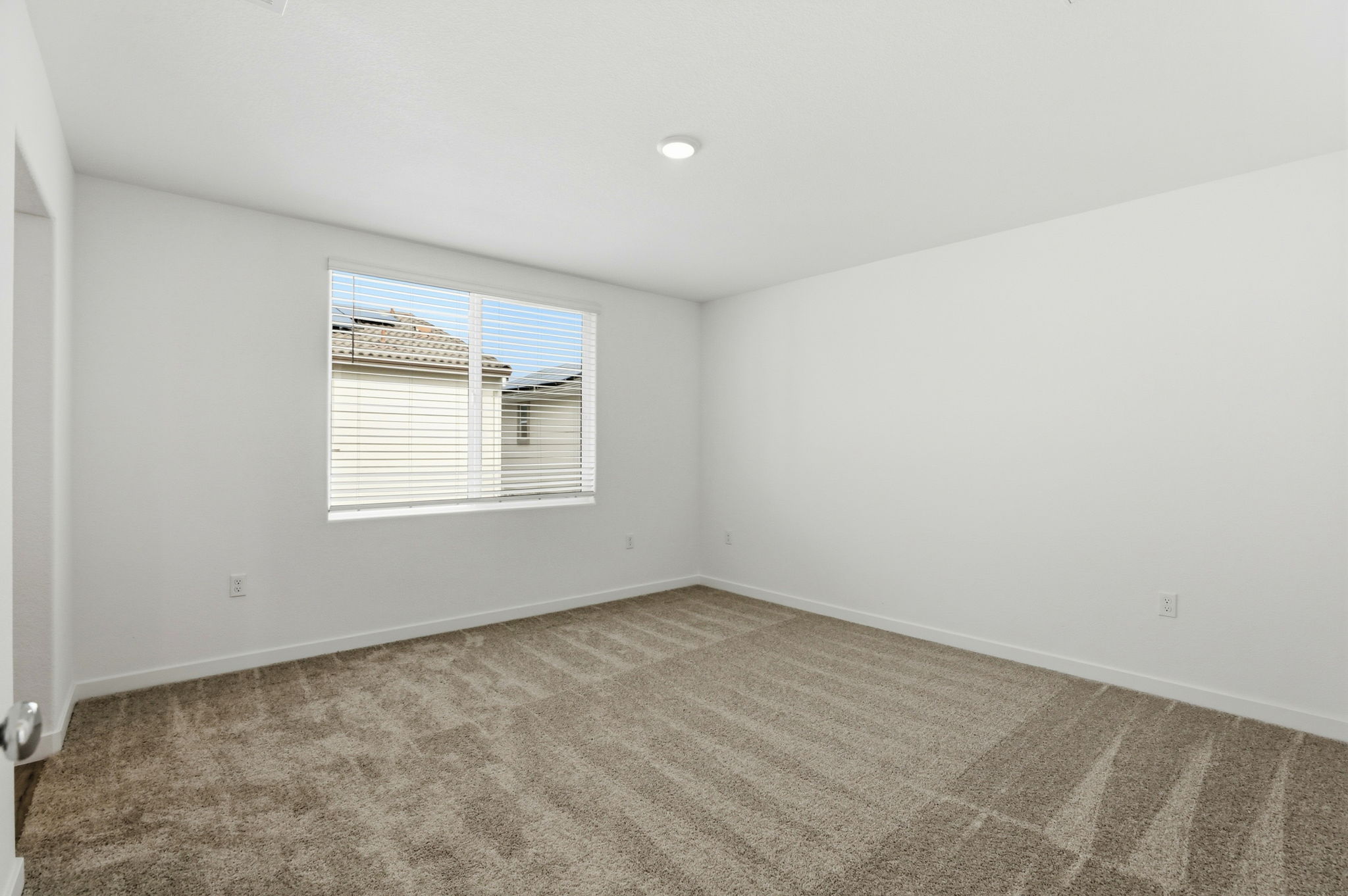 A room with a window and a rug.
