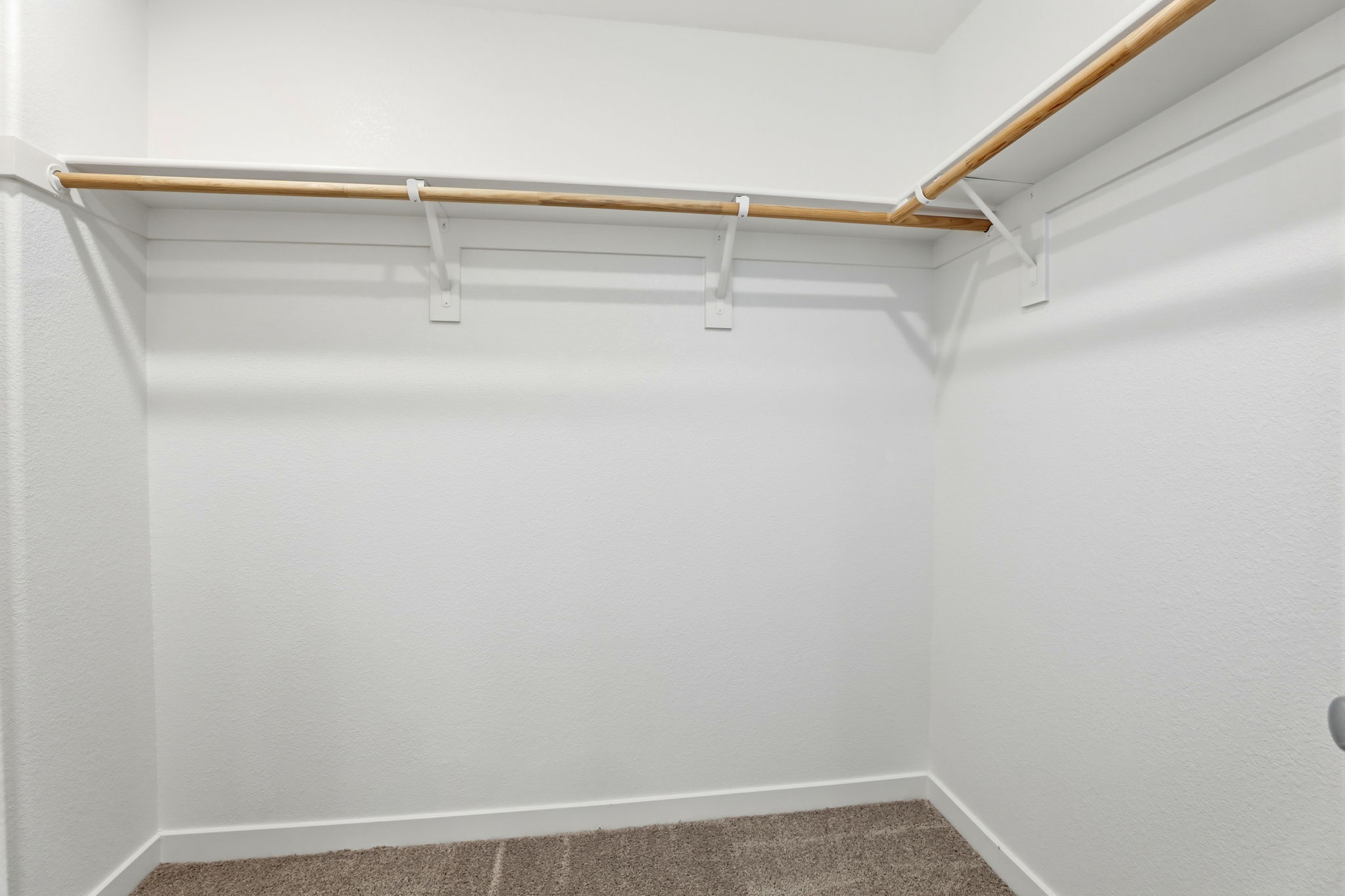 A white wall with a metal bar.