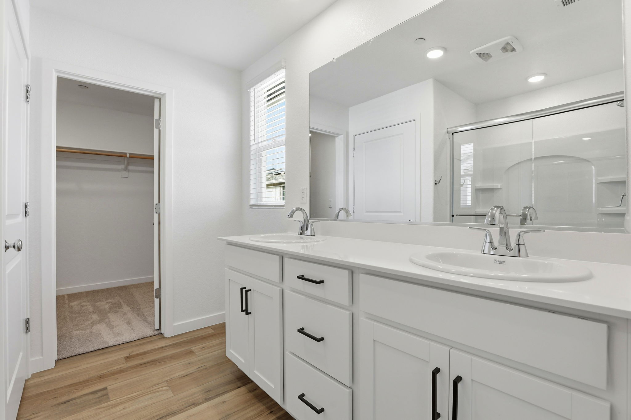 A bathroom with white cabinets.