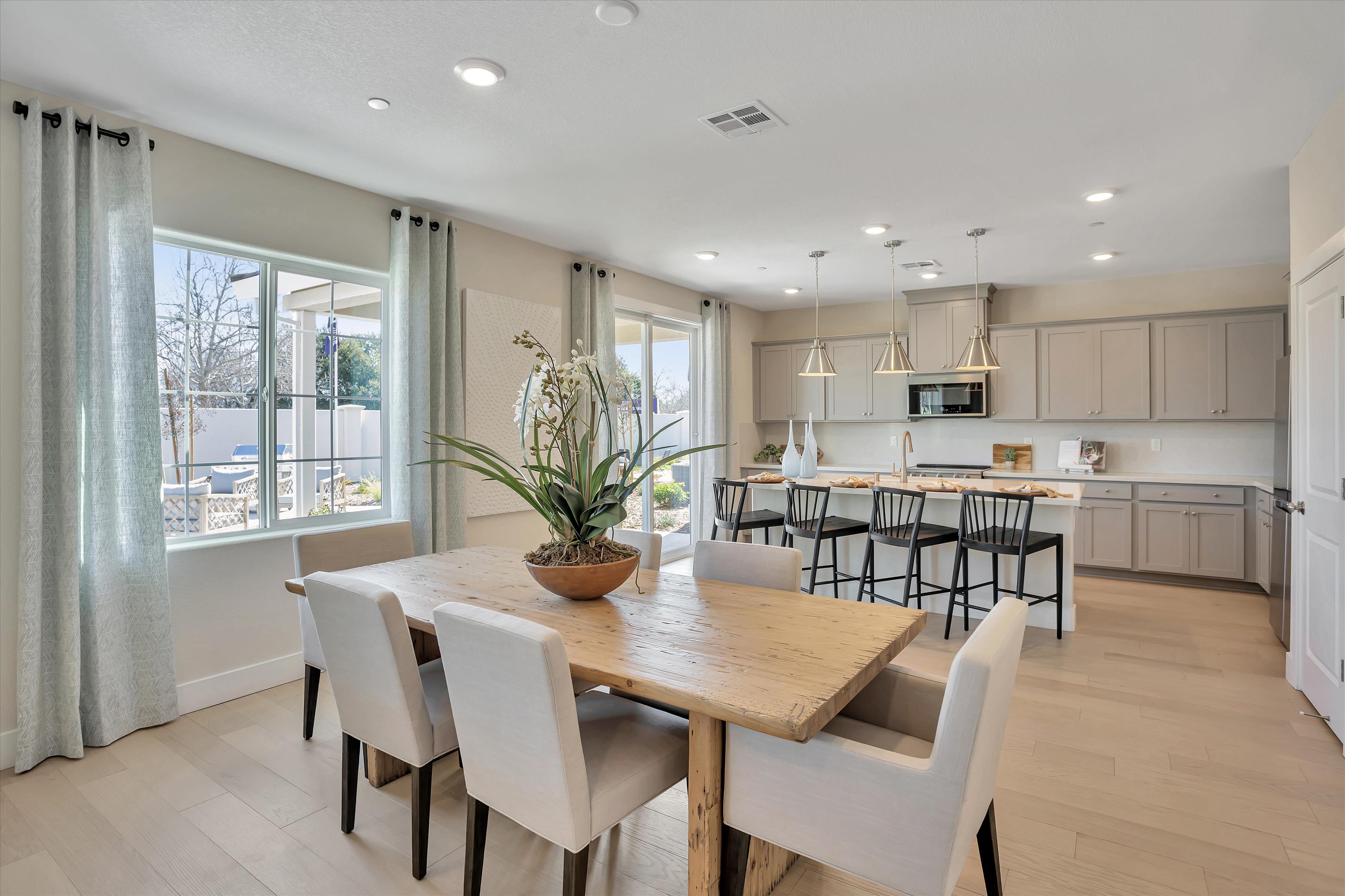 A kitchen with a dining table and chairs.
