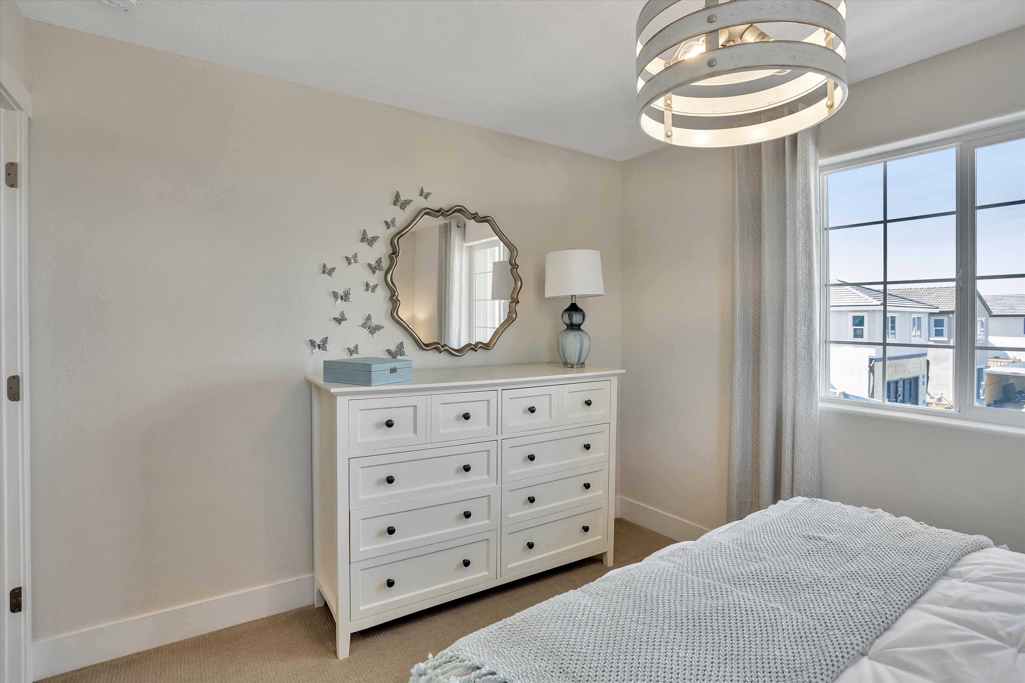 A bedroom with a mirror and a bed.