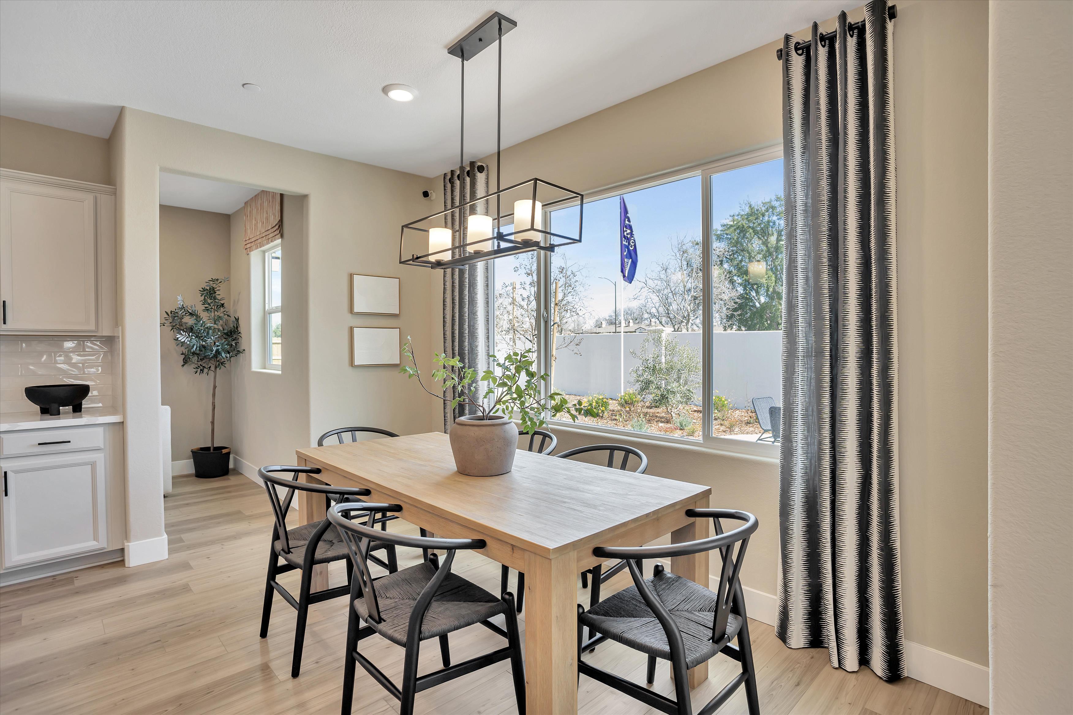A dining room table with chairs and a chandelier.