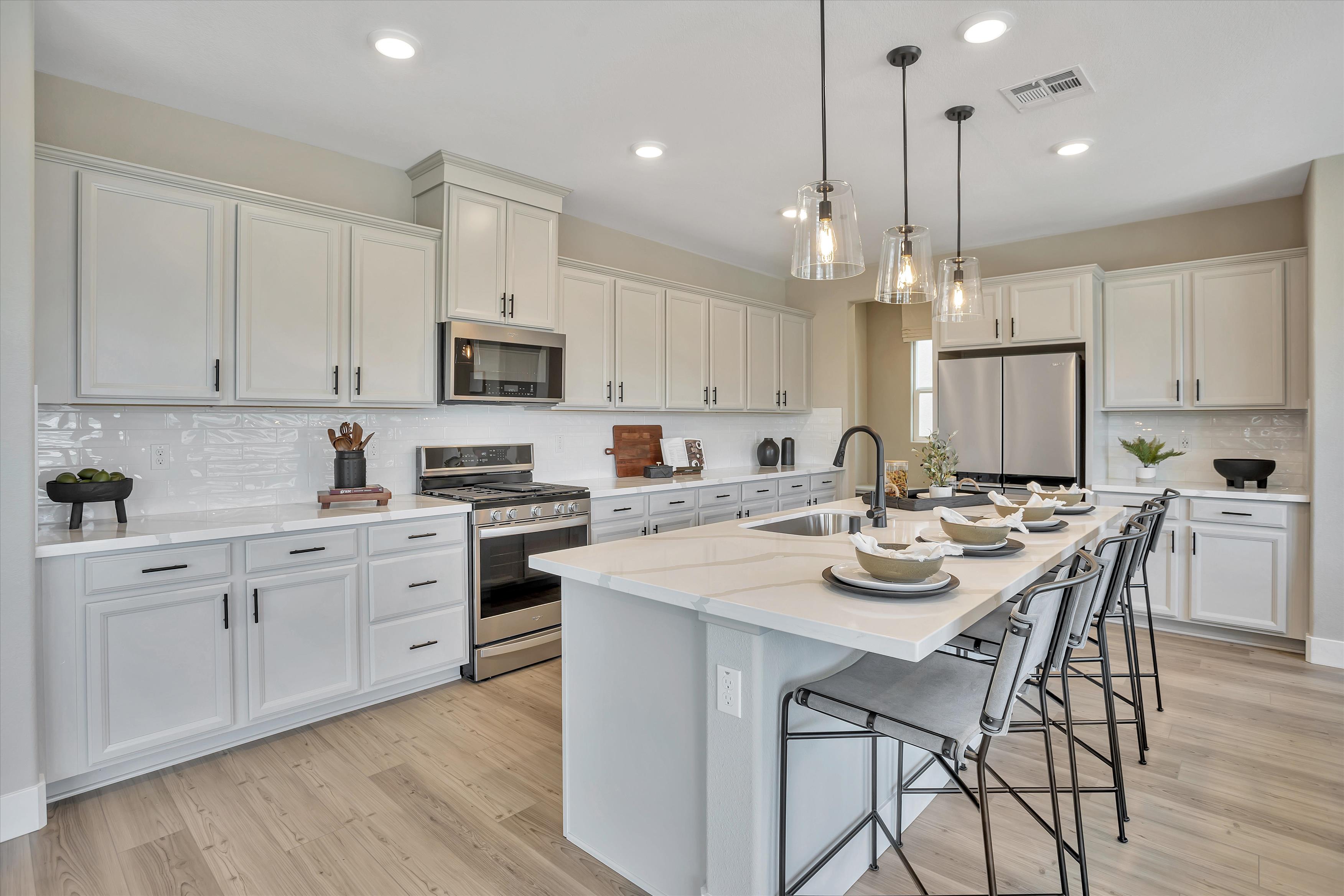 A kitchen with white cabinets.