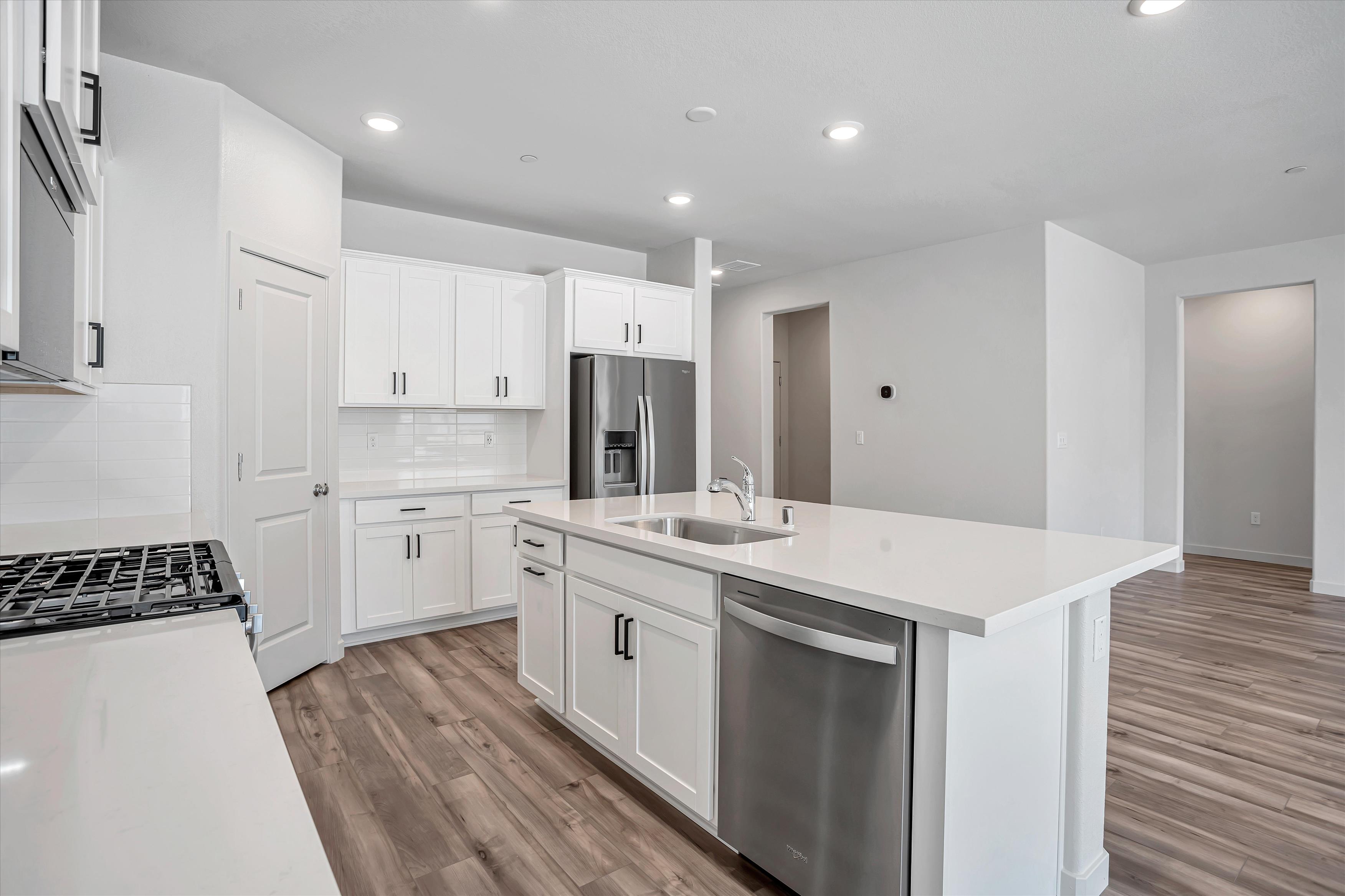 A kitchen with white cabinets.