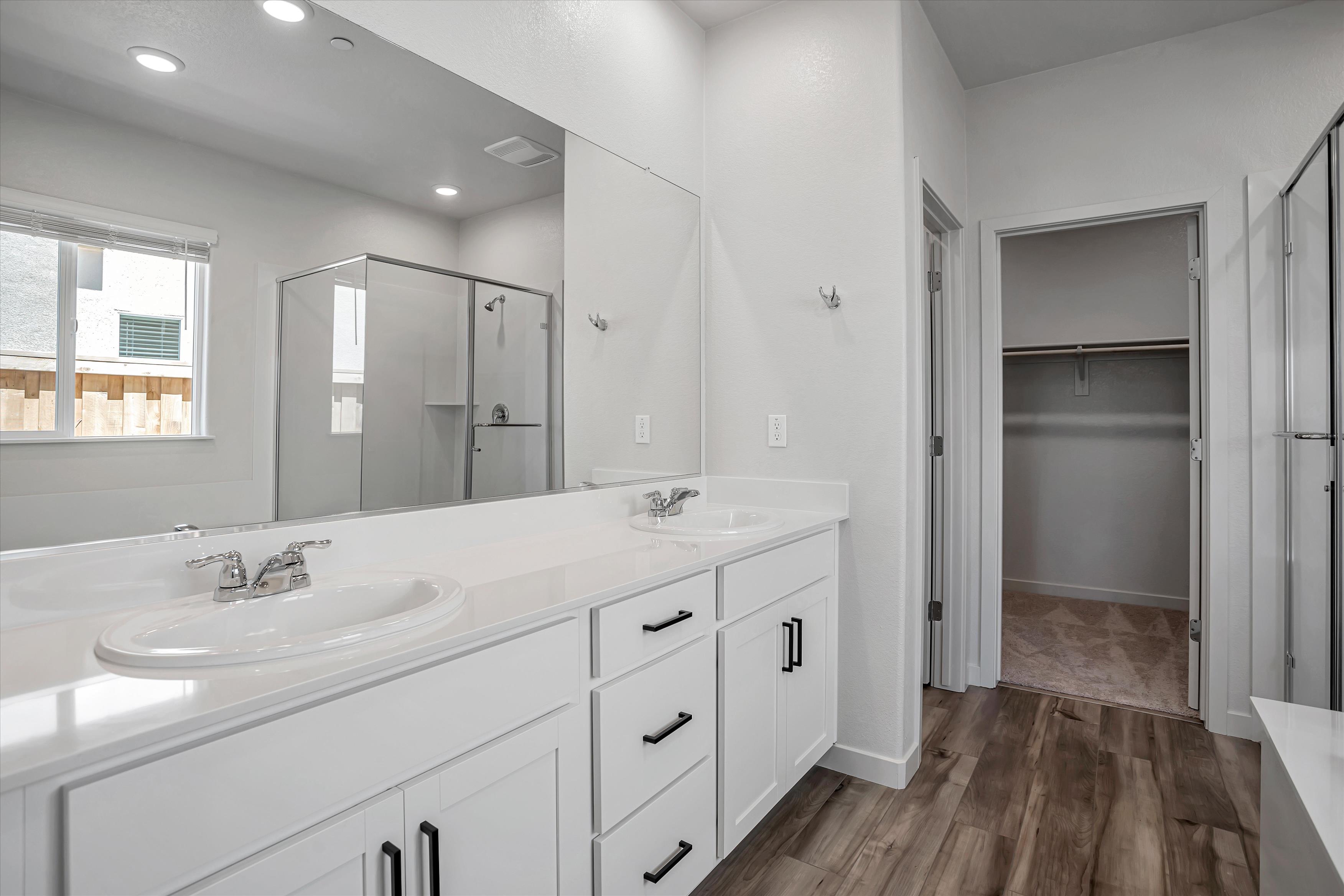 A bathroom with white cabinets.