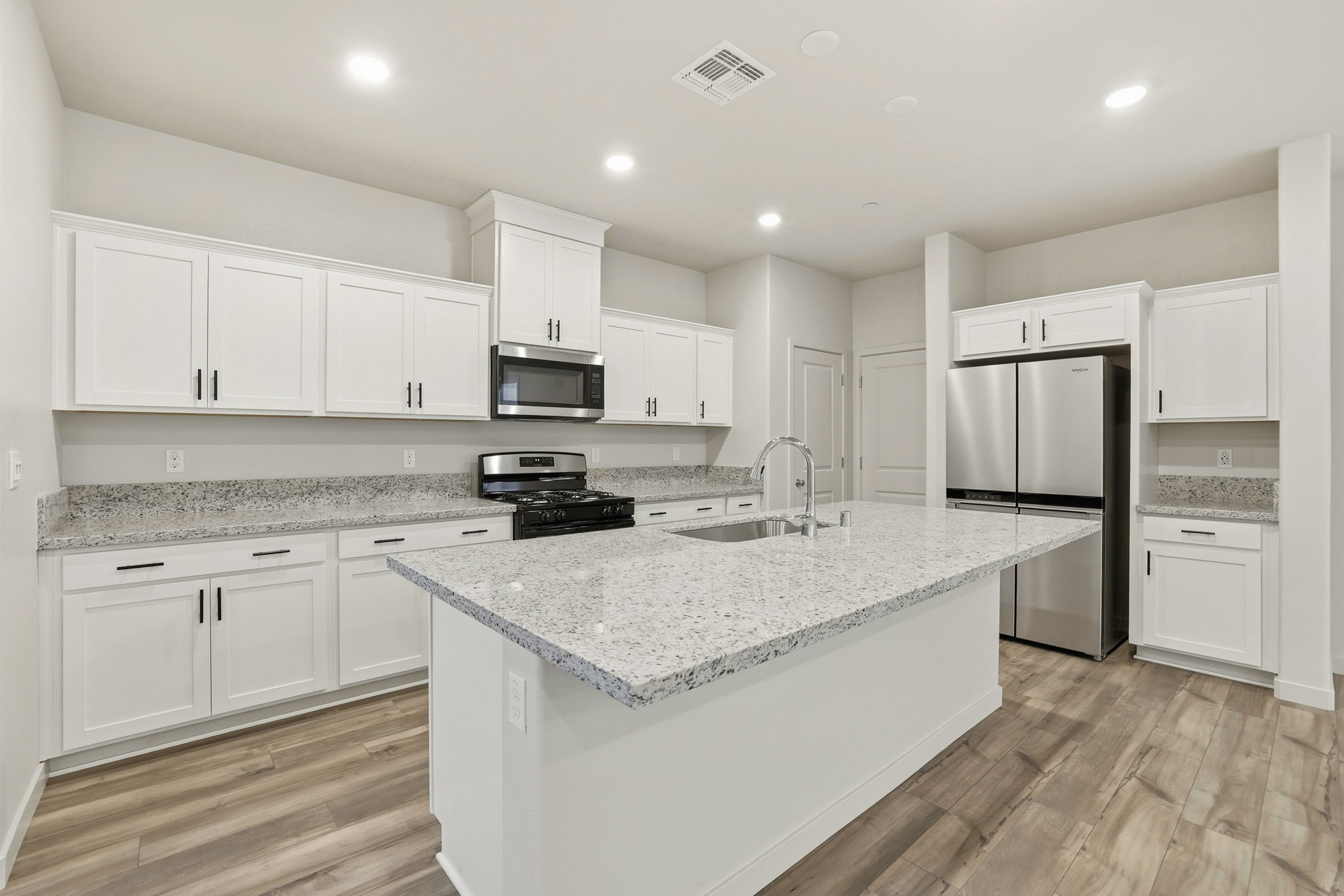 A kitchen with white cabinets.