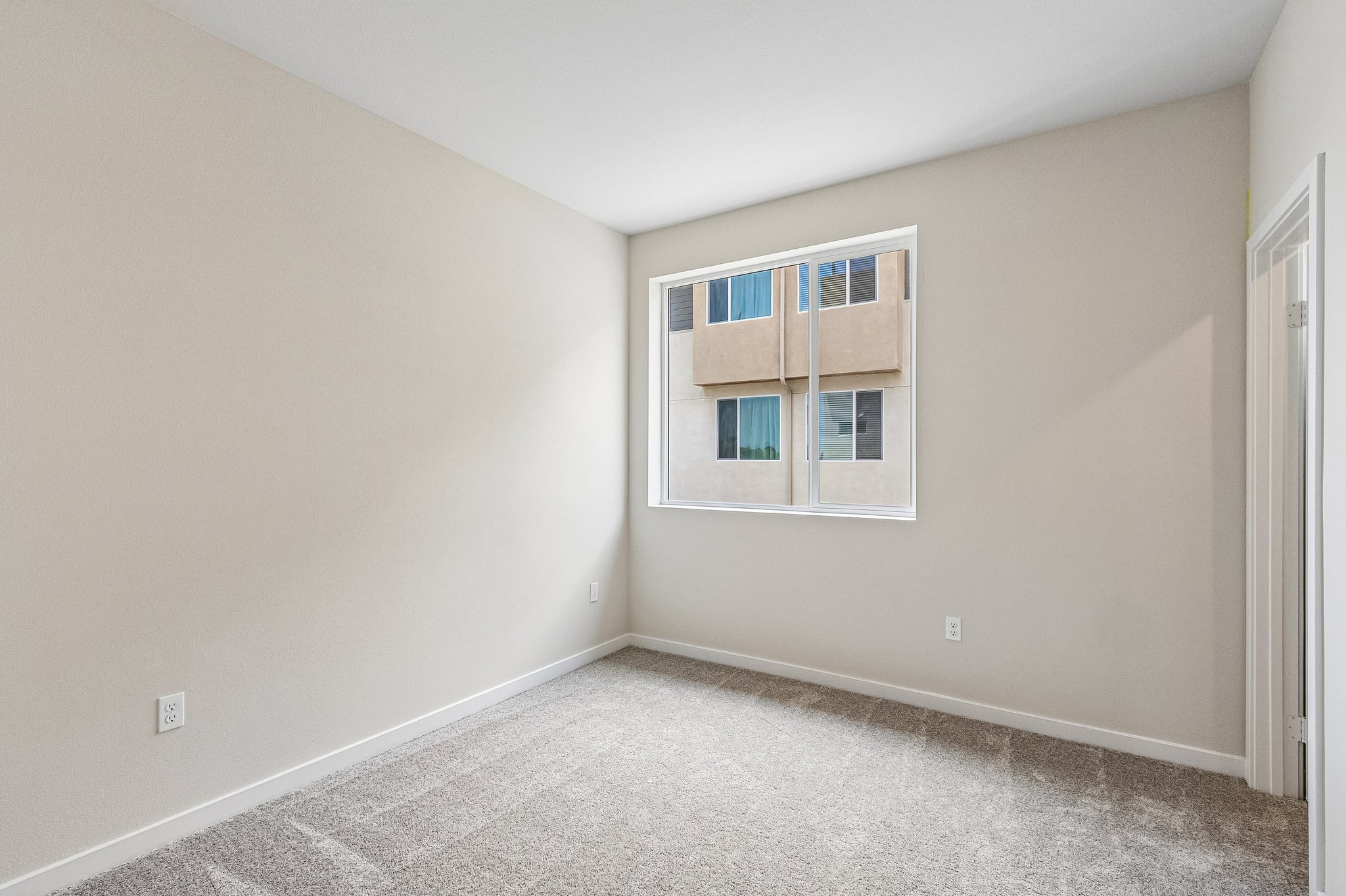 A room with a window and a rug.