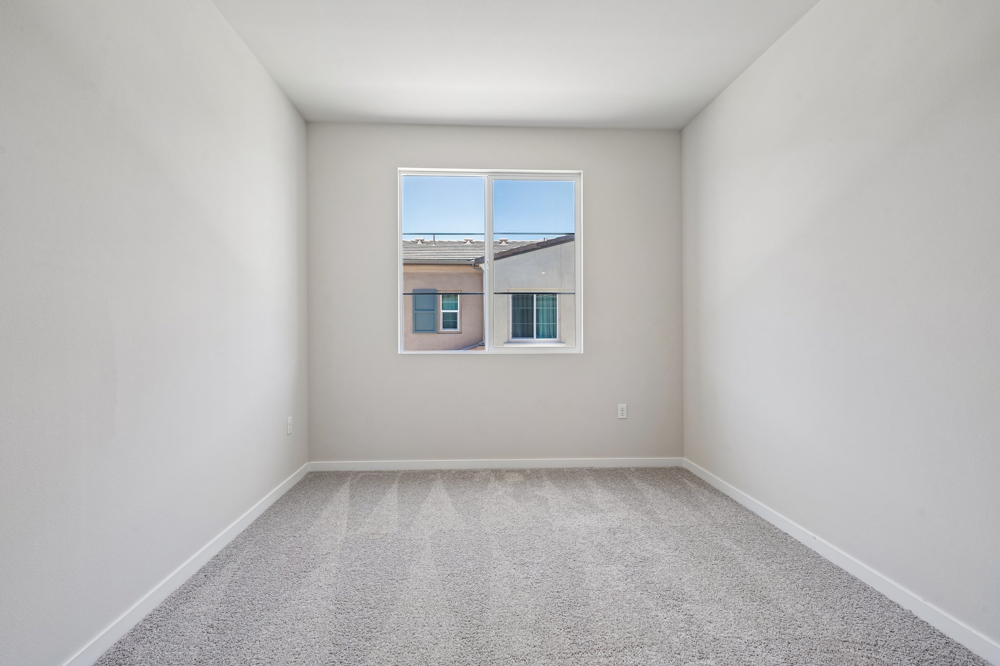 A room with a window and carpet.