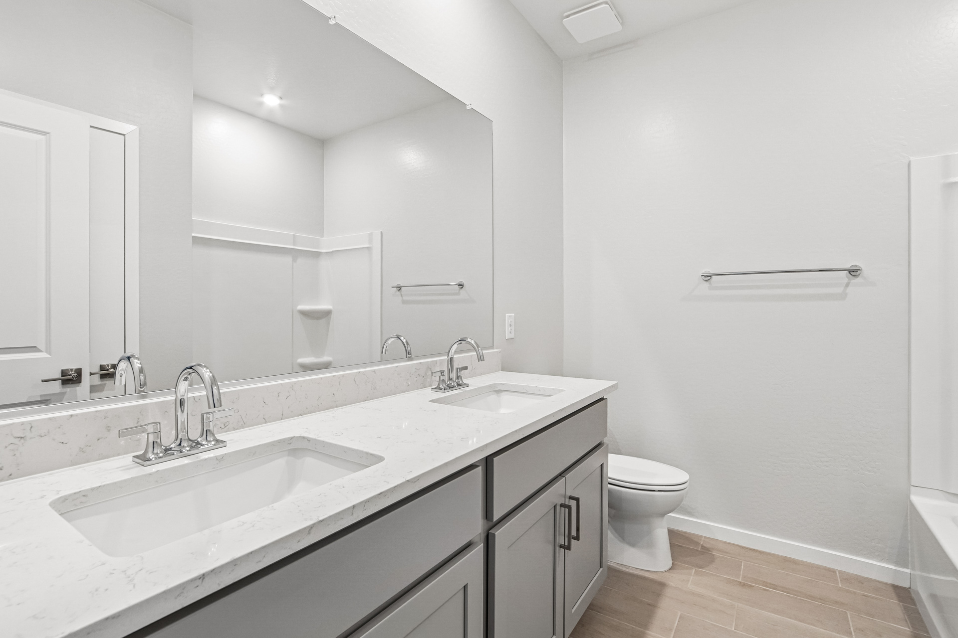 A bathroom with a sink toilet and mirror.