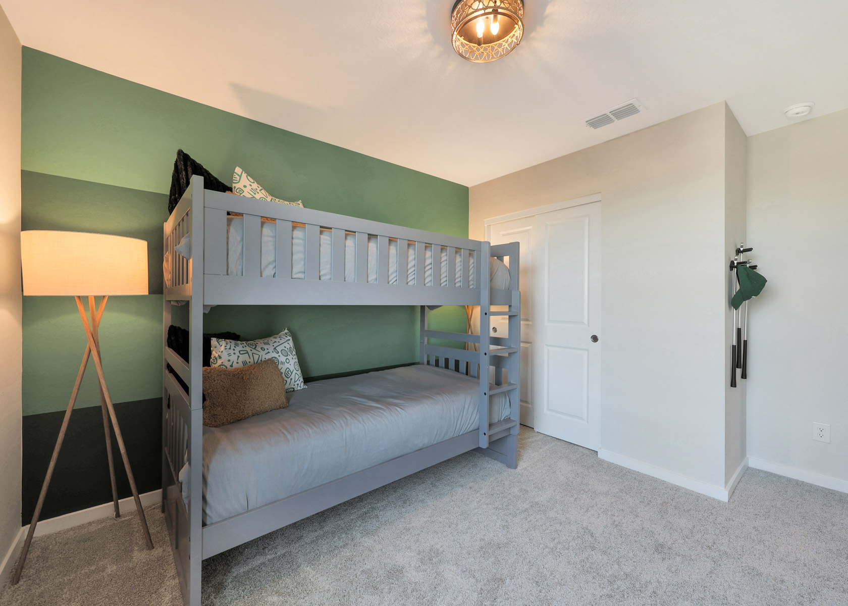 A bedroom with a bed and a lamp.