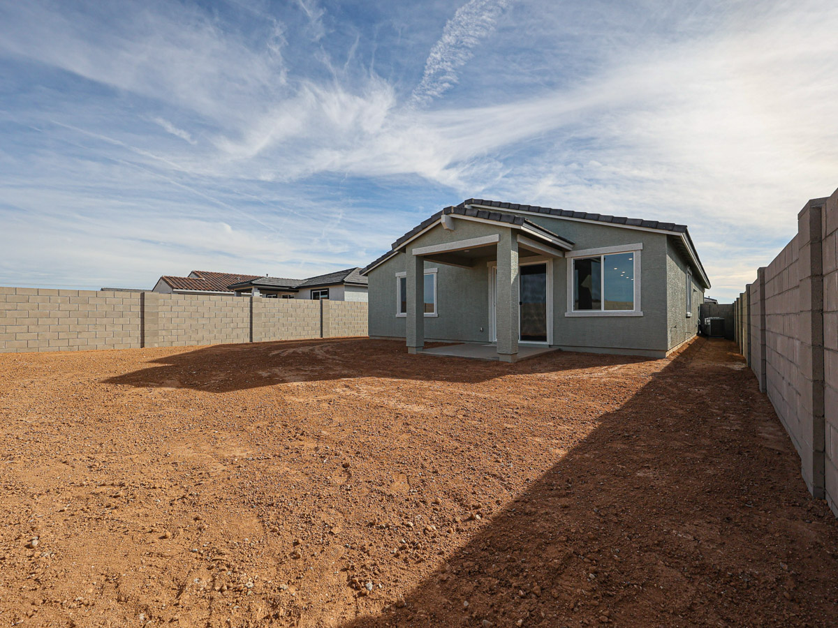 A dirt road leading to a house.