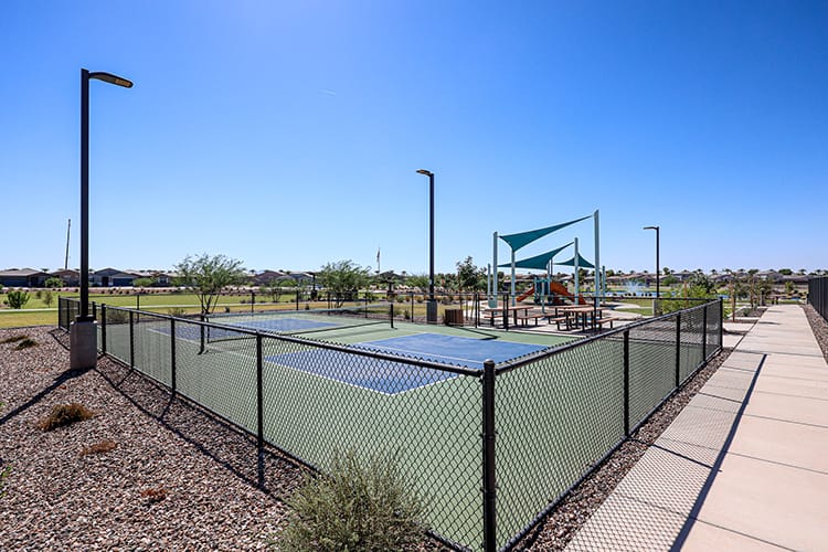 A fenced off area with a metal gate and a walkway.