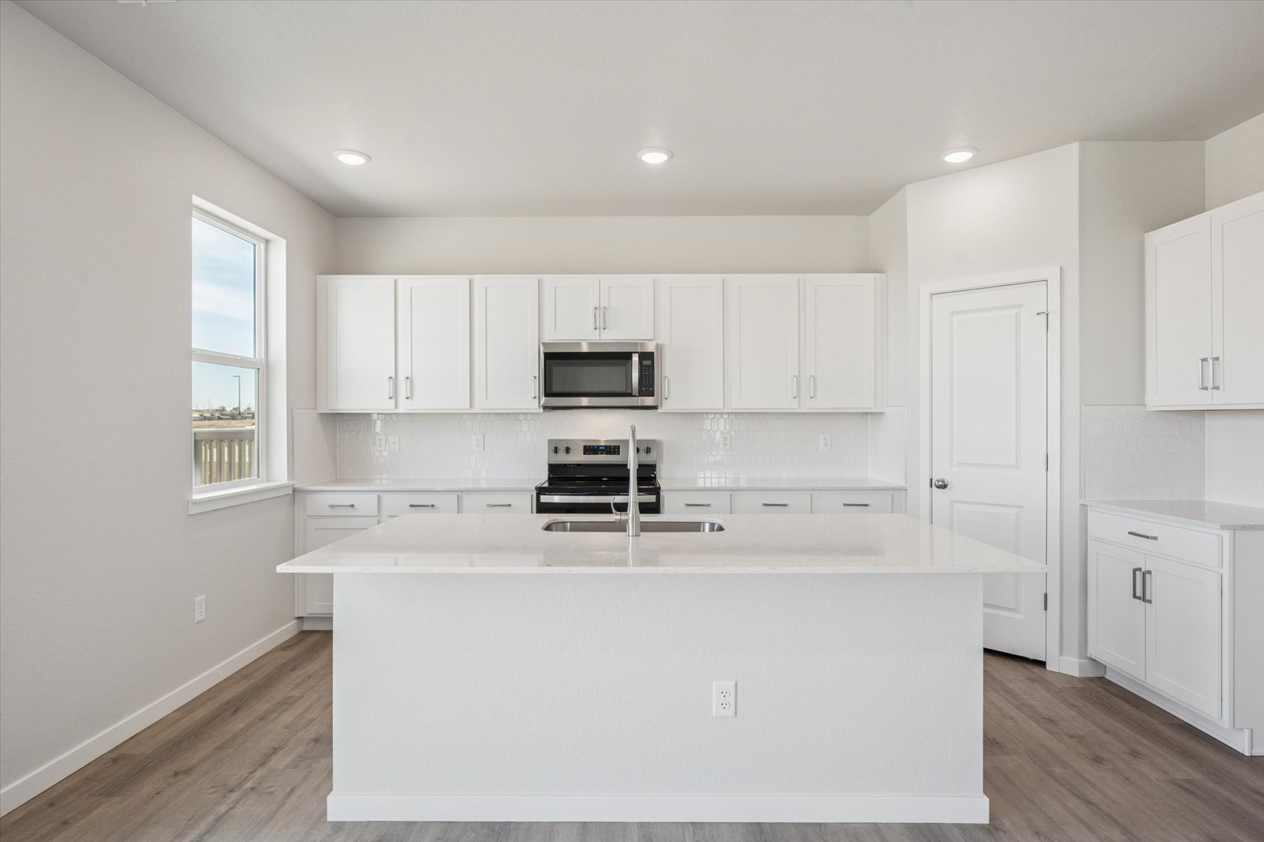 A kitchen with white cabinets.