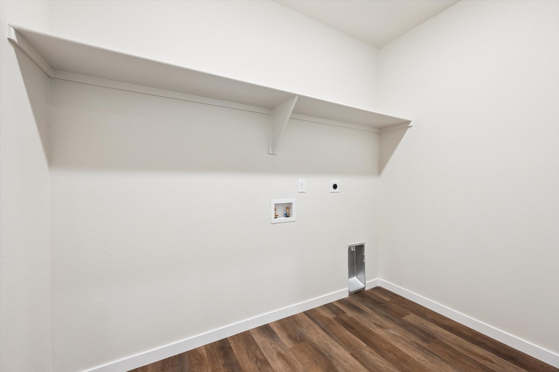 A white room with a wood floor.