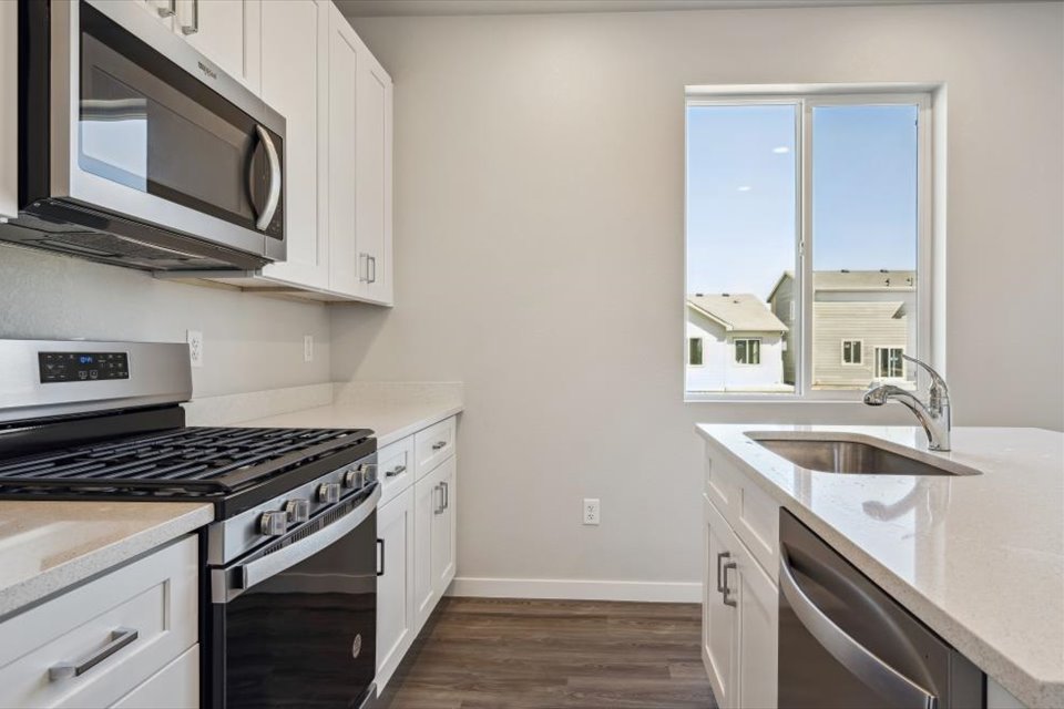 A kitchen with white cabinets.