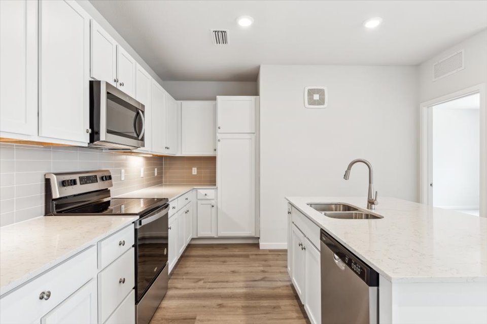 A kitchen with white cabinets.