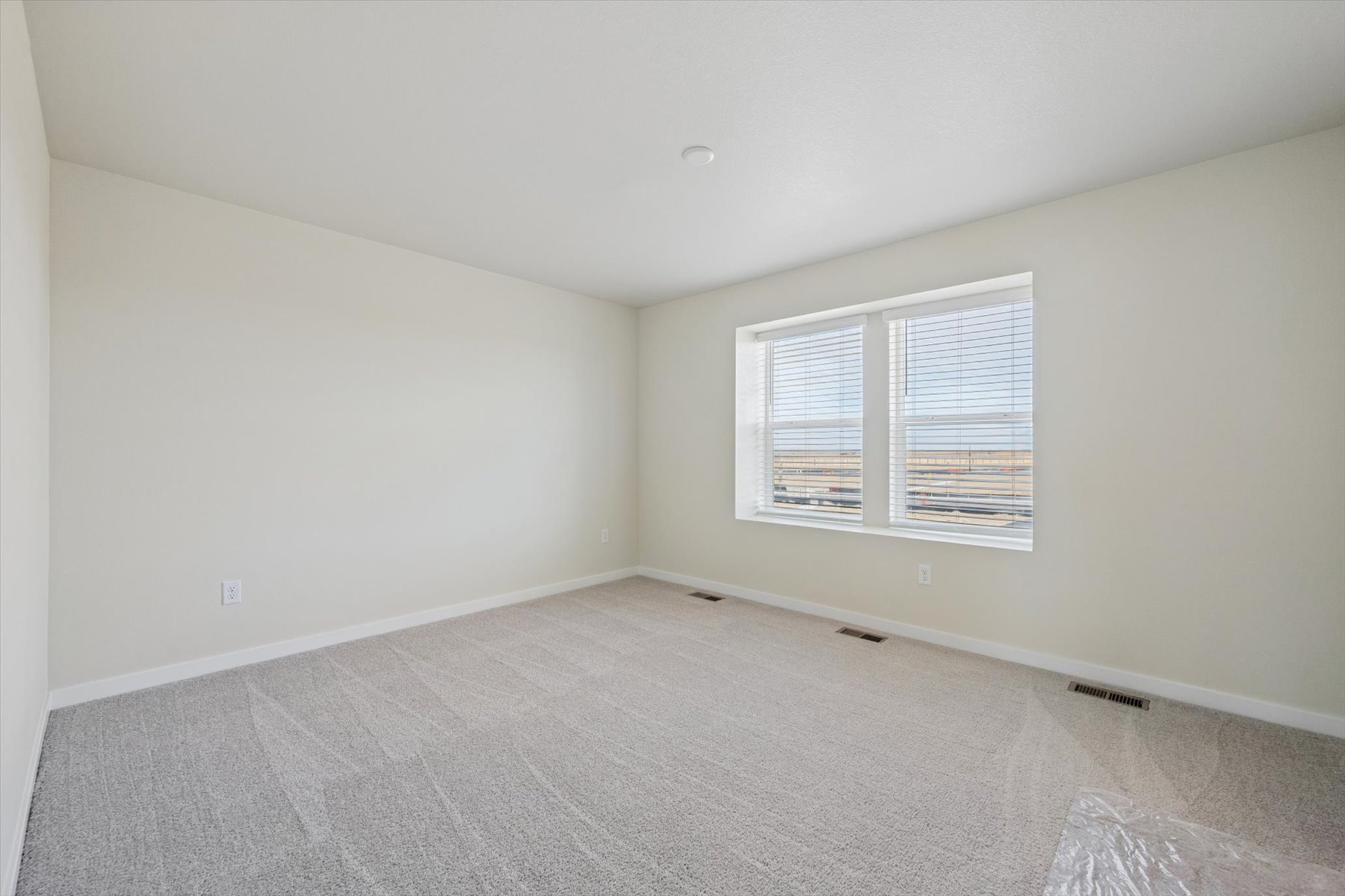 A room with a window and a carpet.