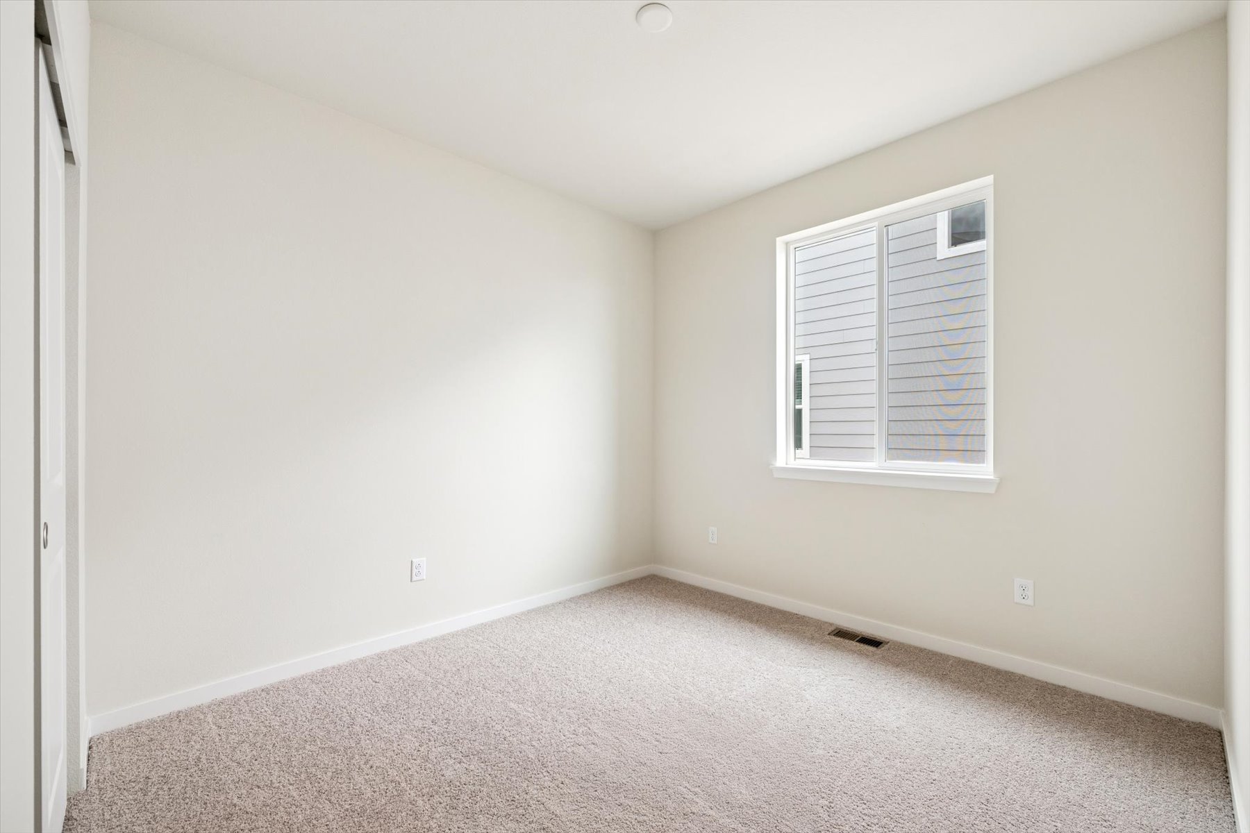 A room with a window and a carpet.