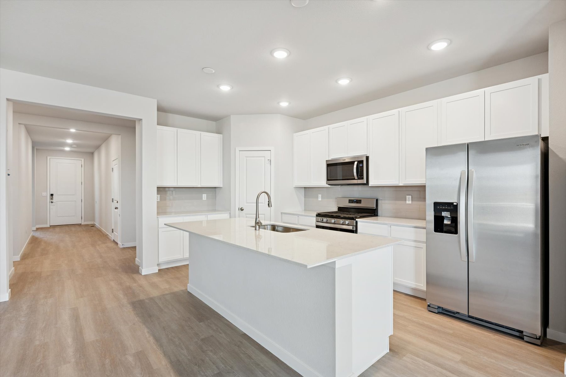 A kitchen with white cabinets.