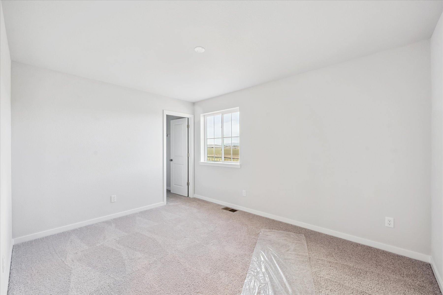 A room with a window and carpet.