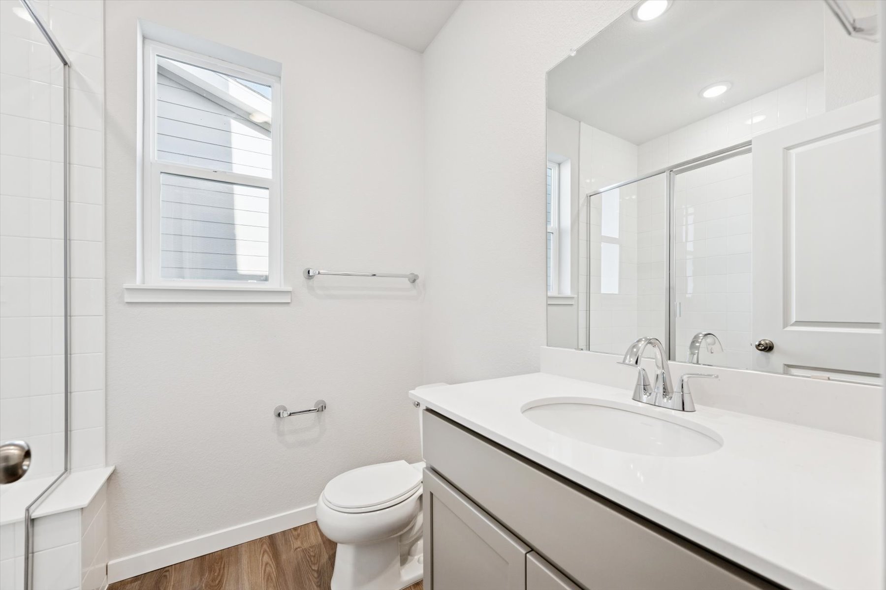 A bathroom with a sink toilet and mirror.