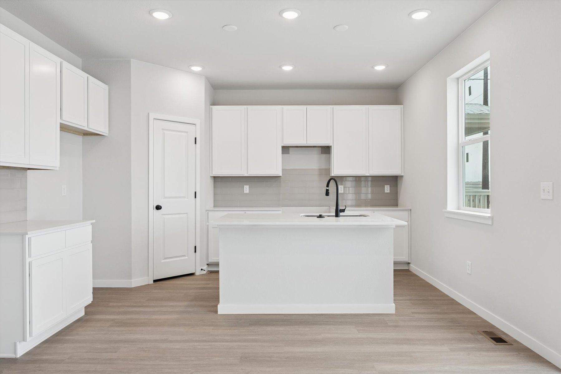 A kitchen with white cabinets.
