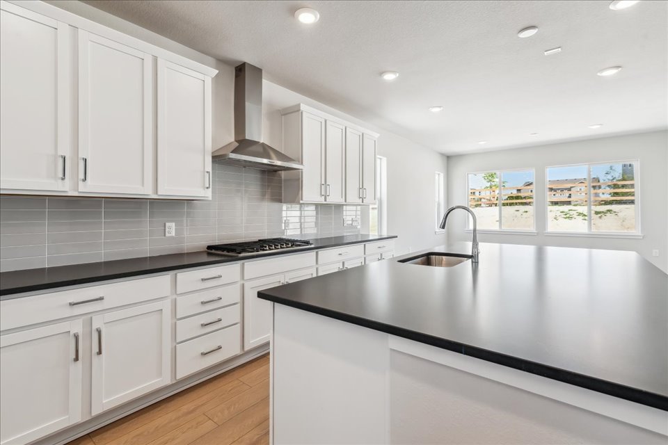 A kitchen with white cabinets.