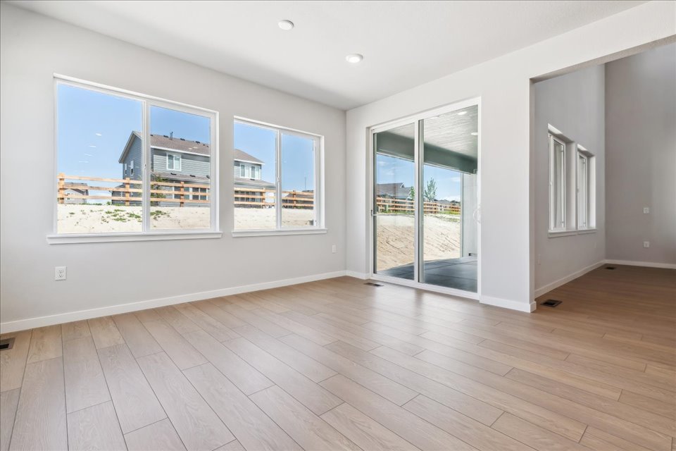 A room with a wood floor and a large window.