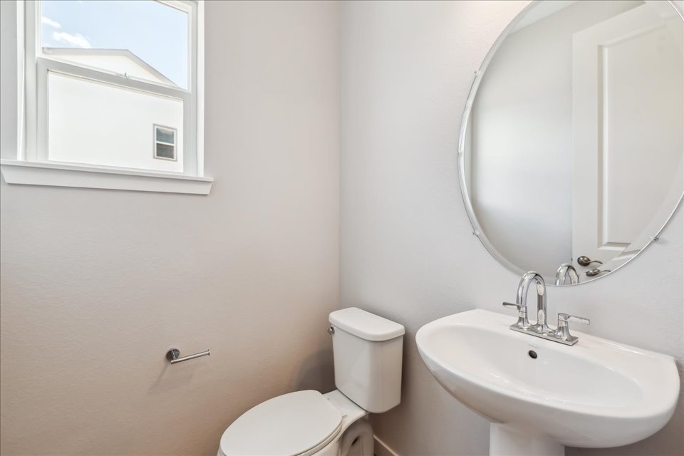 A bathroom with a round mirror.