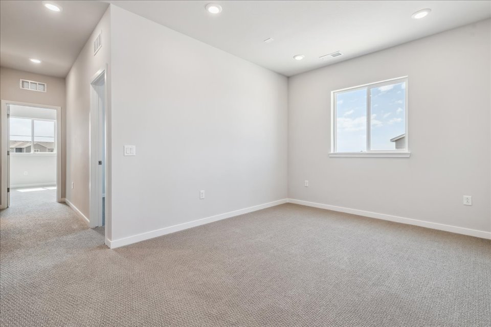 A room with a white wall and a window.