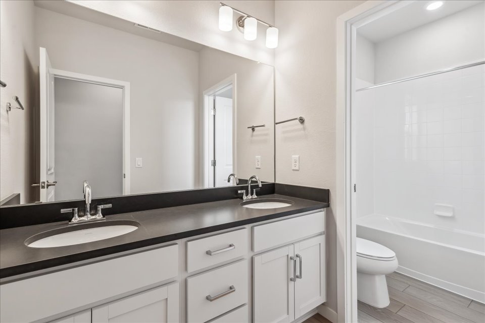 A bathroom with a large mirror.