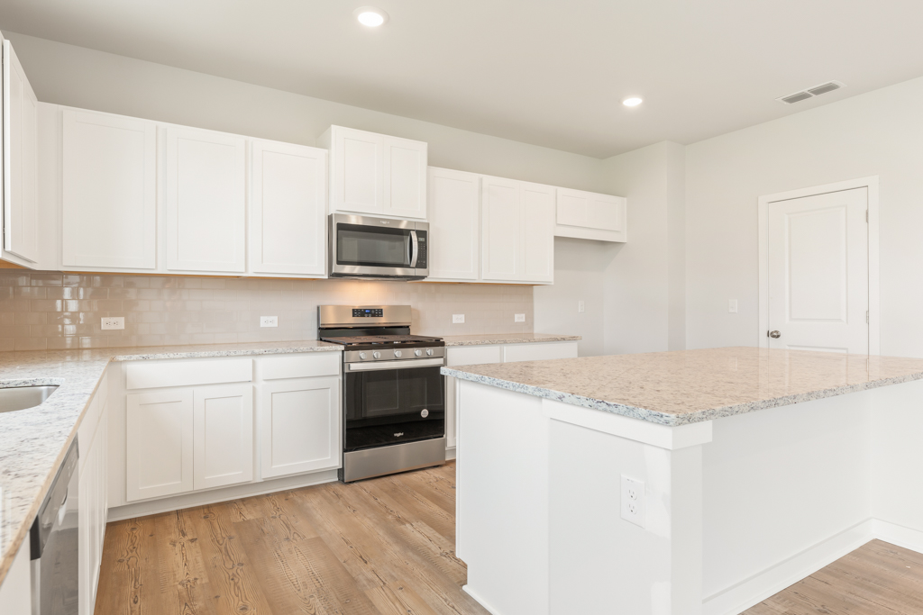 A kitchen with white cabinets.