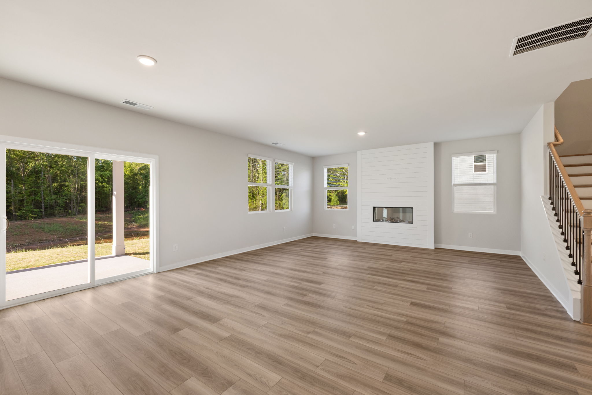 A large empty room with a wood floor and a wood floor.