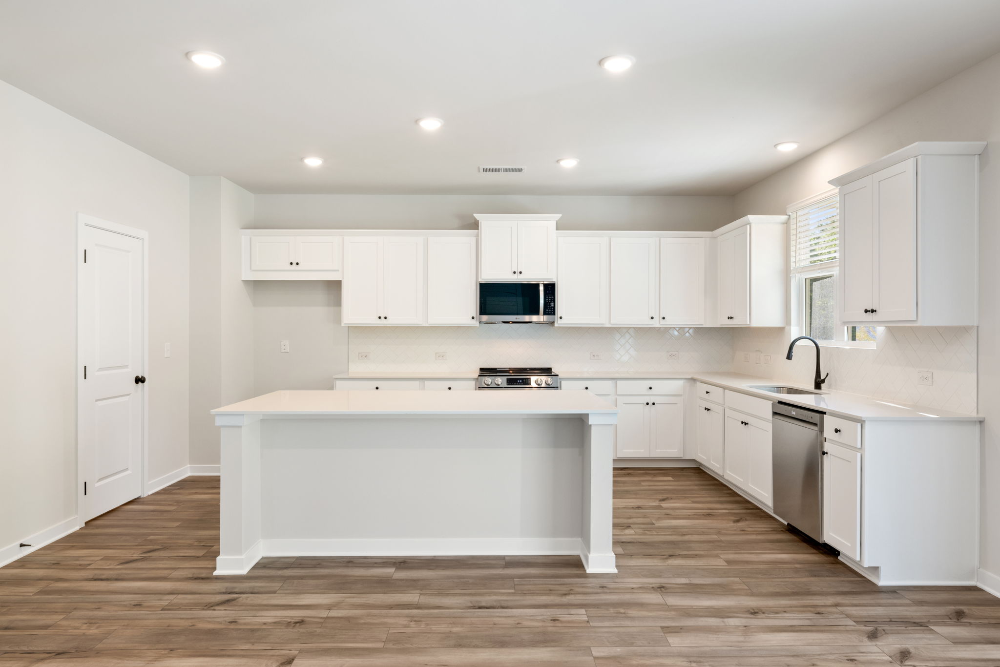 A kitchen with white cabinets.